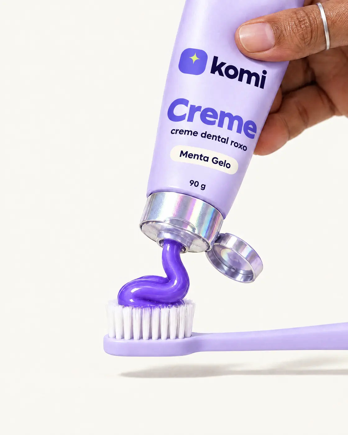 Creme Komi saindo roxo do tubo direto na escova lavanda