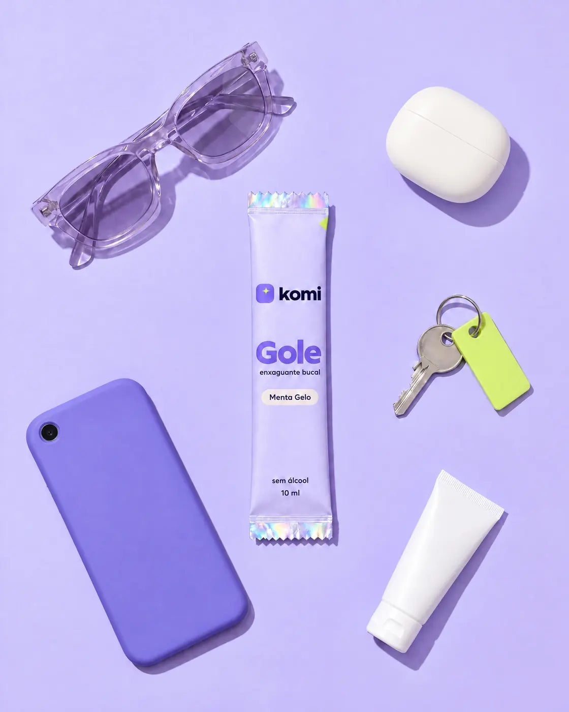Sachê do Gole entre óculos, celular e chaves sobre fundo lavanda